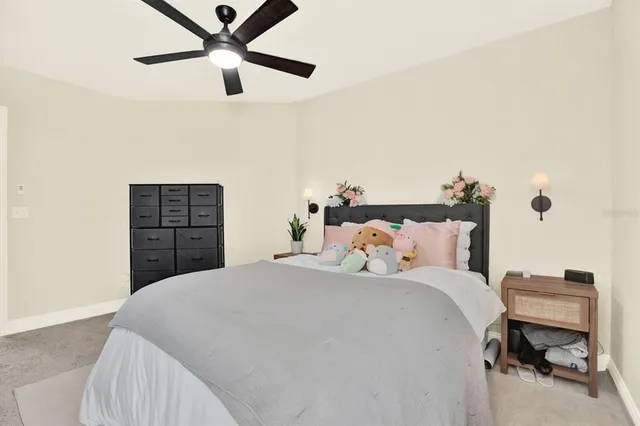 a bedroom with a bed and a ceiling fan