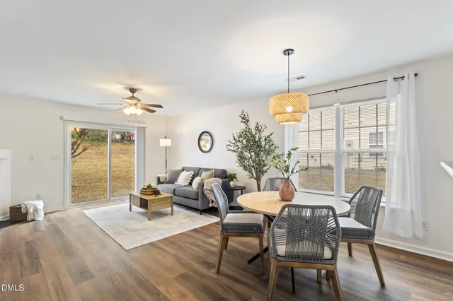 a dining room with furniture a chandelier and wooden floor