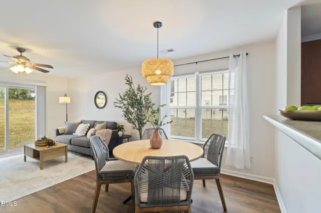 a dining room with furniture a chandelier and wooden floor