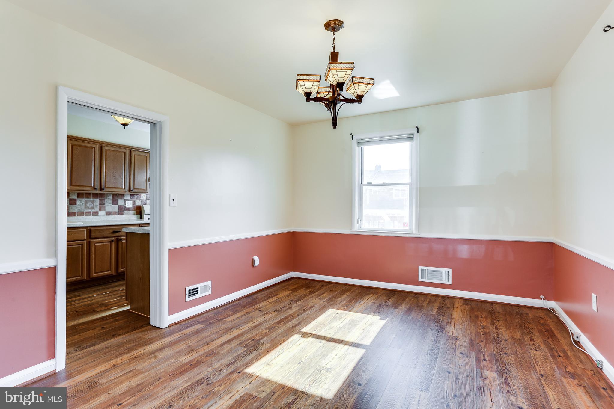 6117 Edlynne Road Baltimore, MD 21239 - Photo 11 of 18 a view of room with window and wooden floor