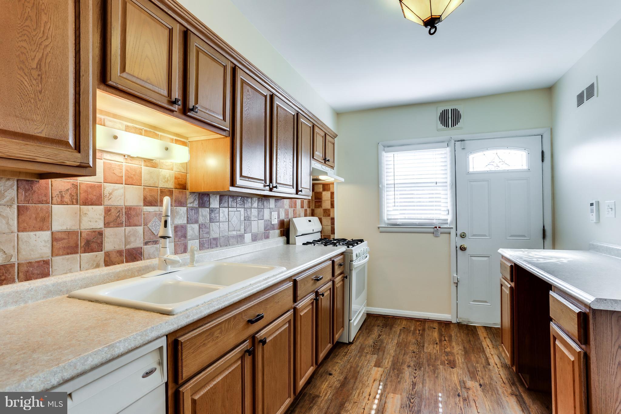 6117 Edlynne Road Baltimore, MD 21239 - Photo 10 of 18 a kitchen with a sink stove and cabinets