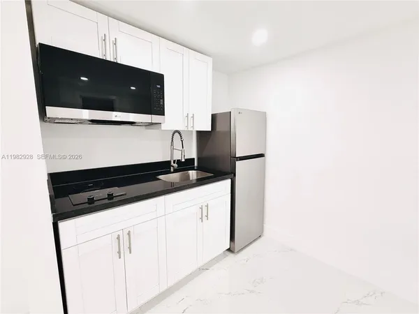 a kitchen with stainless steel appliances granite countertop a refrigerator and a stove
