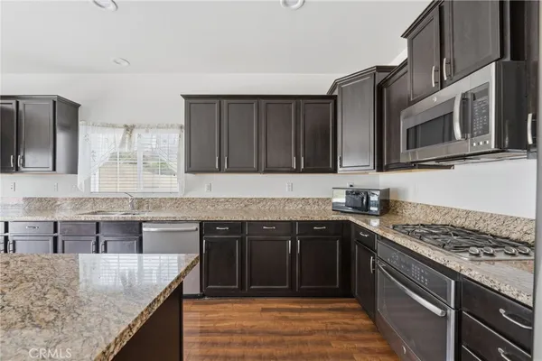a kitchen with stainless steel appliances granite countertop a stove top oven microwave and cabinets