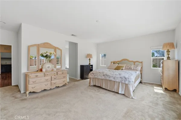 a spacious bedroom with a bed and dresser