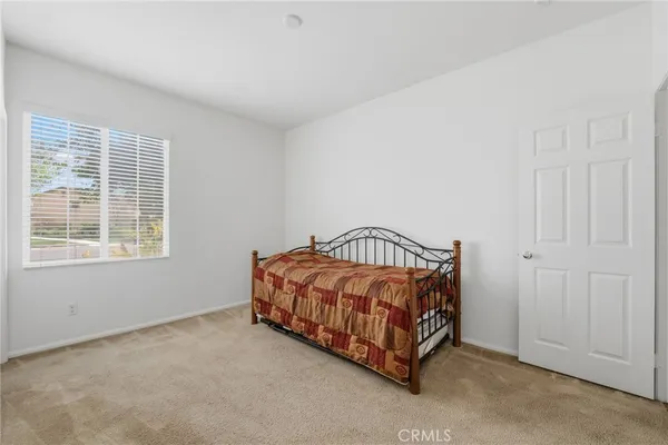 a spacious bedroom with a bed and a window