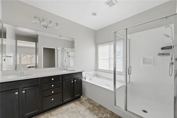 a spacious bathroom with a granite countertop sink mirror and a bathtub
