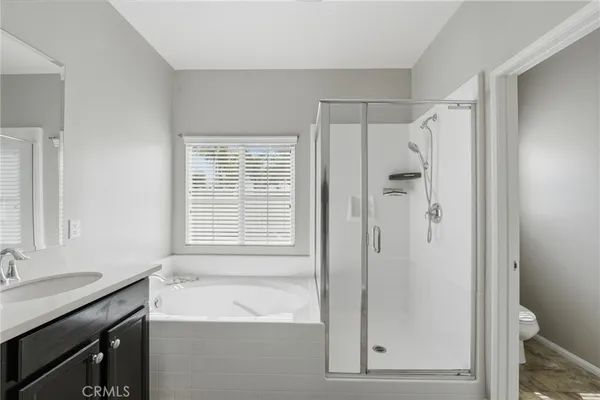 a bathroom with a shower sink vanity and a toilet