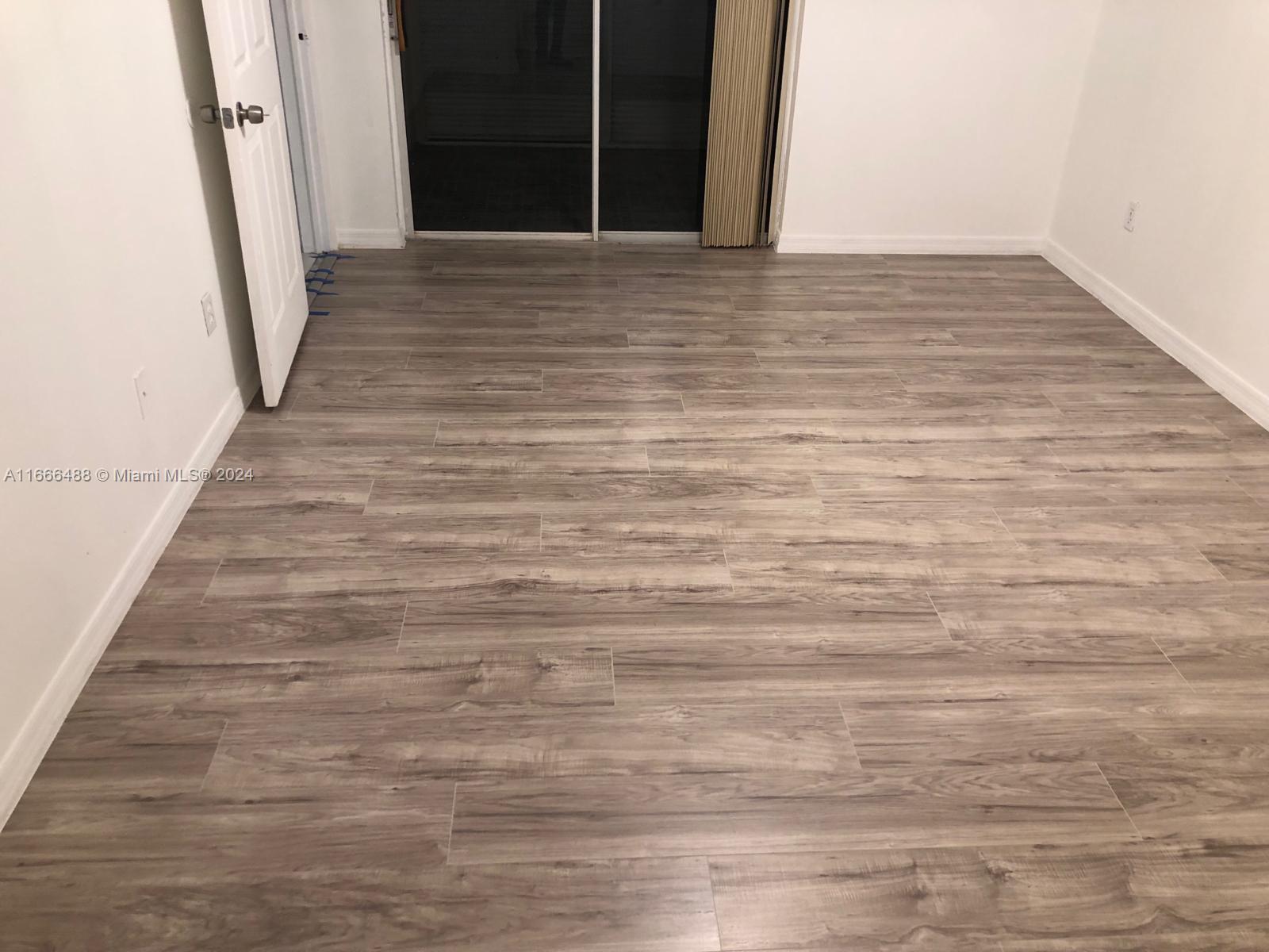 435 Northeast 210th Cir Terrace, Unit 10323 Miami, FL 33179 - Photo 10 of 15 a view of an empty room with wooden floor