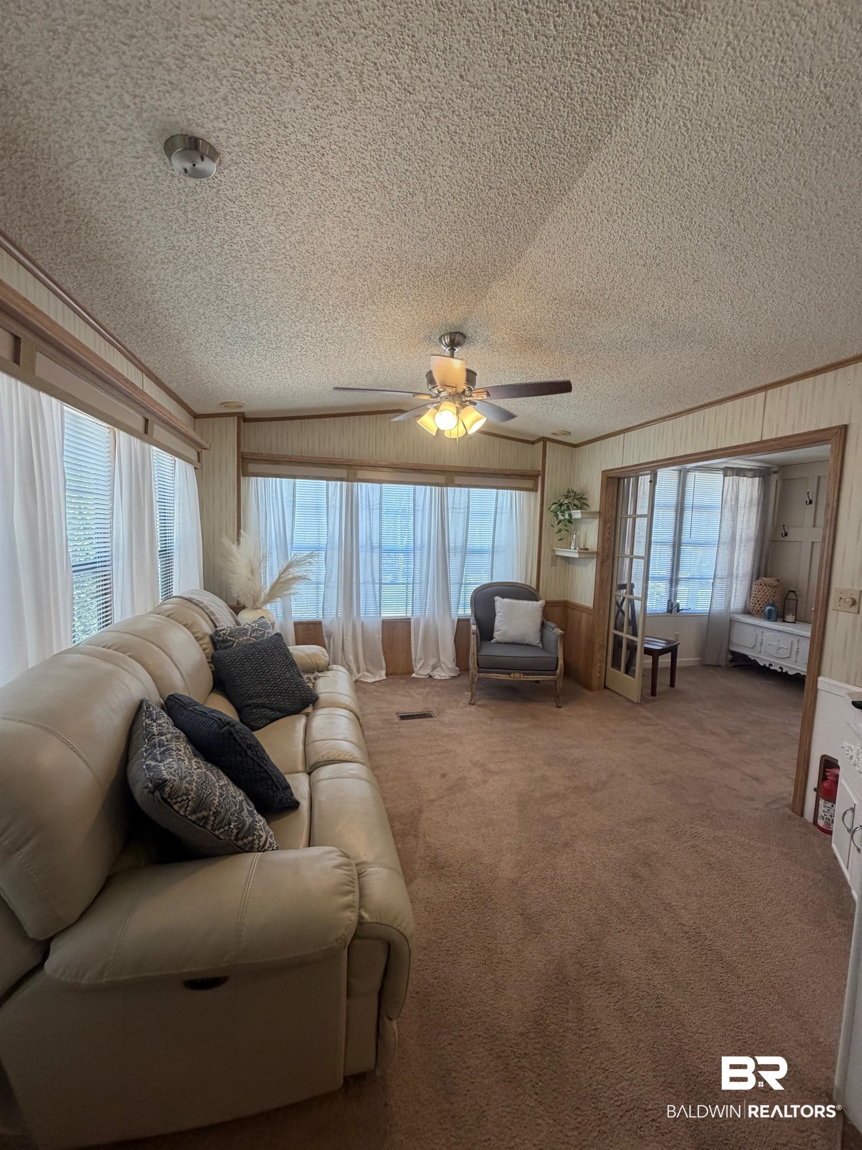 685 Escambia Loop Lillian, AL 36549 - Photo 8 of 43 Carpeted living room featuring a ceiling fan and a textured ceiling