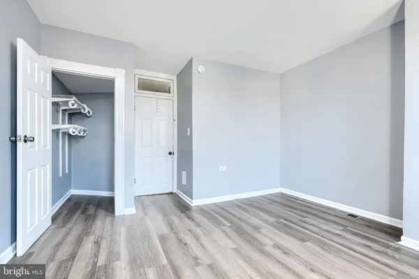 a view of a room with wooden floor and a bathroom