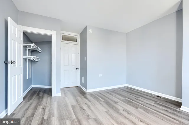 a view of a room with wooden floor and a bathroom