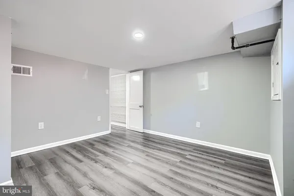 a view of an empty room with wooden floor