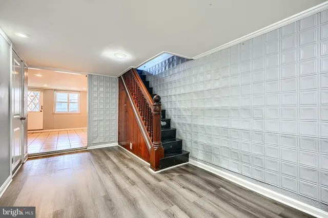 a view of an empty room with wooden floor and stairs