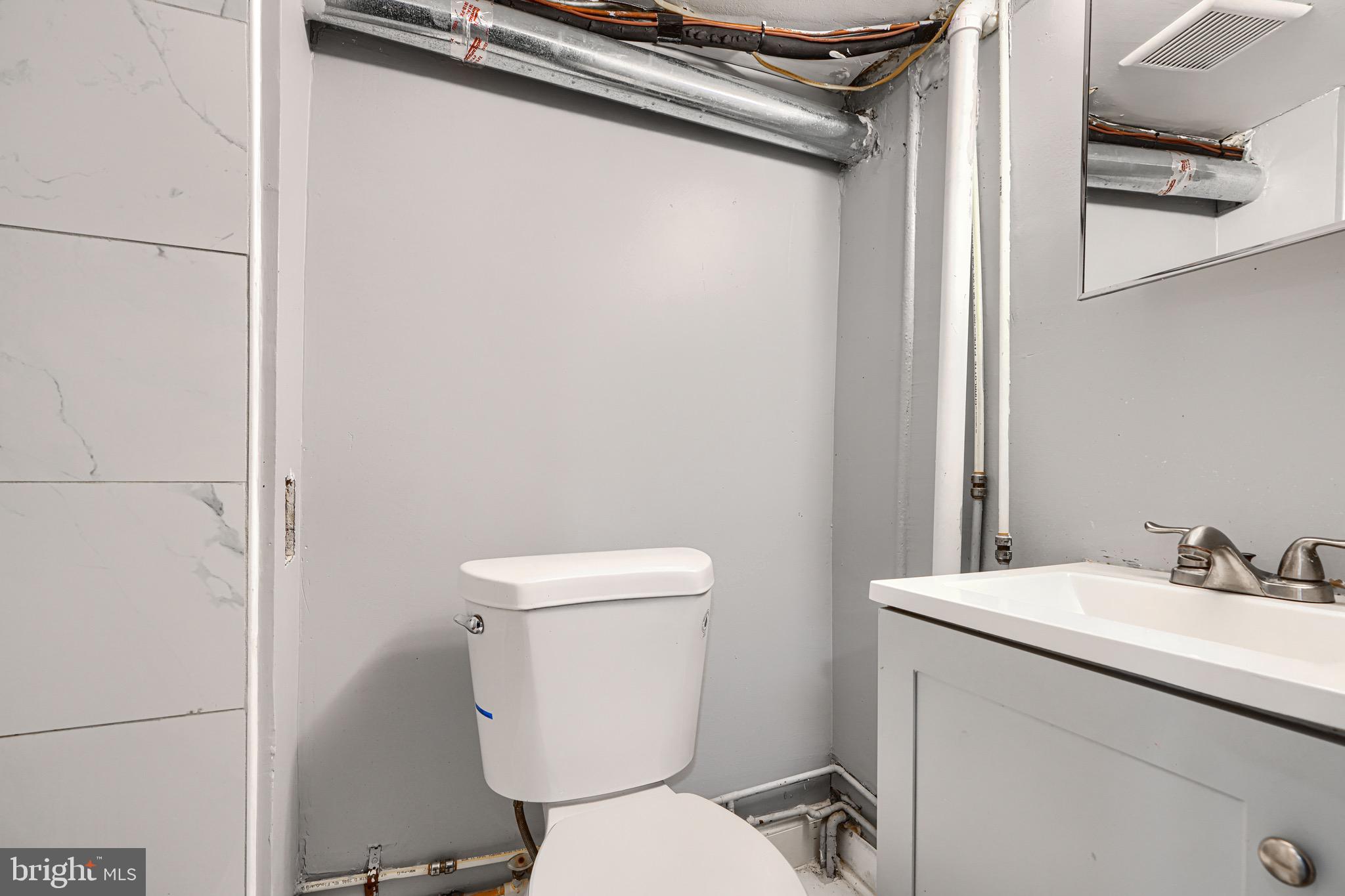 424 North Linwood Avenue Baltimore, MD 21224 - Photo 27 of 28 a white toilet sitting next to a bathroom sink