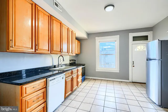 a kitchen with stainless steel appliances granite countertop a stove a sink and a refrigerator
