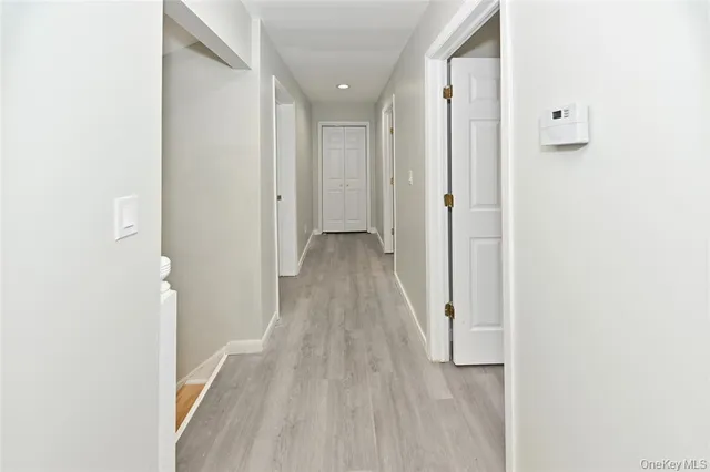 an empty room with wooden floor chandelier fan and windows