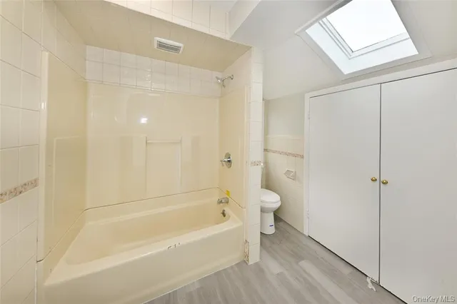 a view of a kitchen with white cabinets and wooden floor