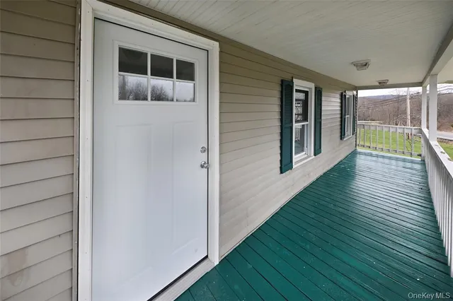 a view of a porch with wooden floor and fence
