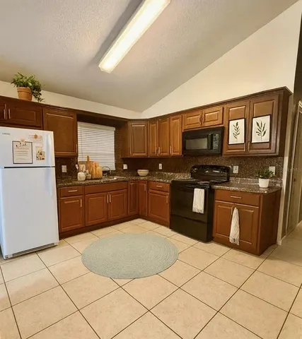 a kitchen with stainless steel appliances granite countertop a stove a sink and a refrigerator