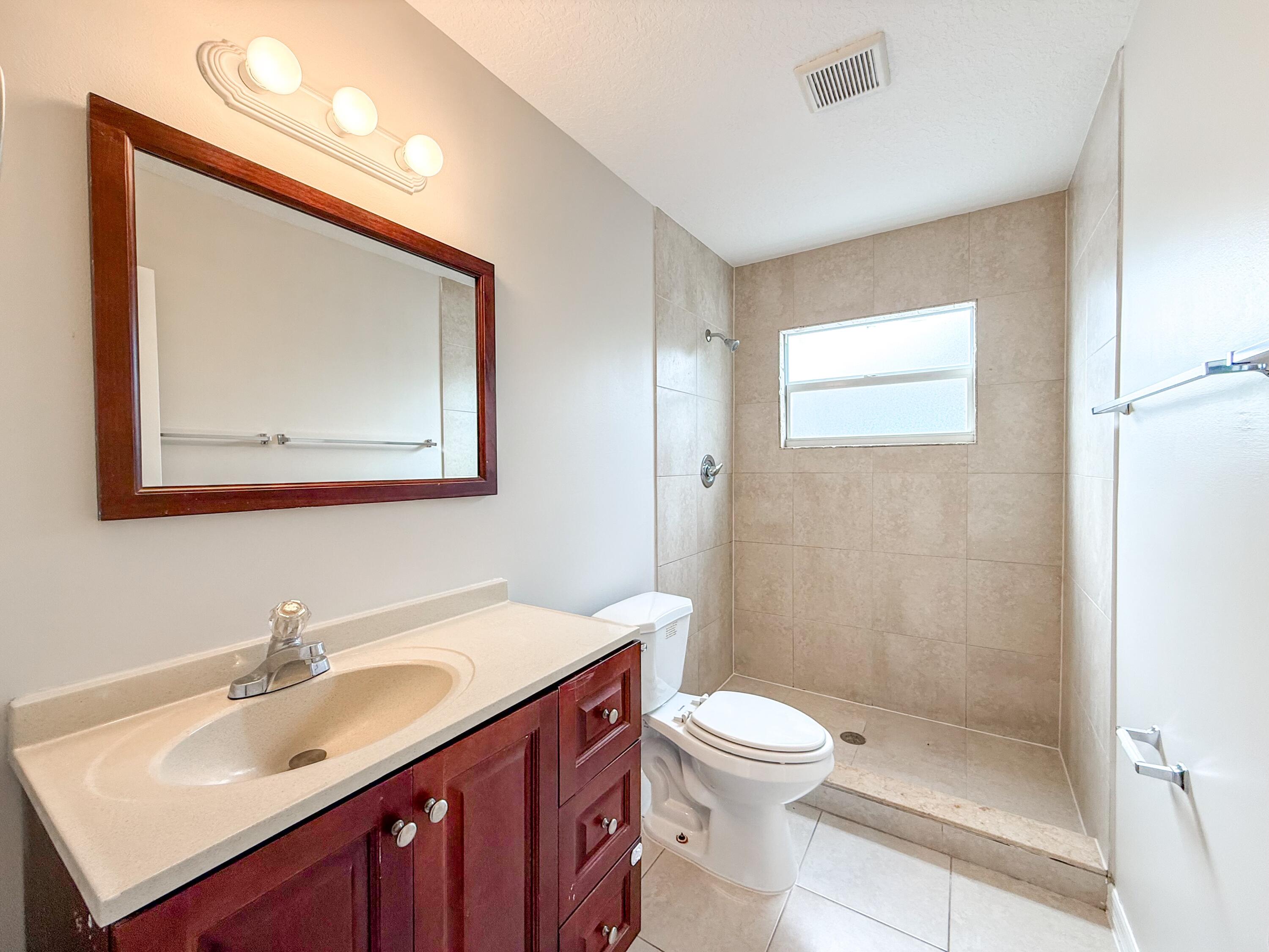 2719 Richard Road West Palm Beach, FL 33403 - Photo 8 of 14 a bathroom with a sink a toilet and shower