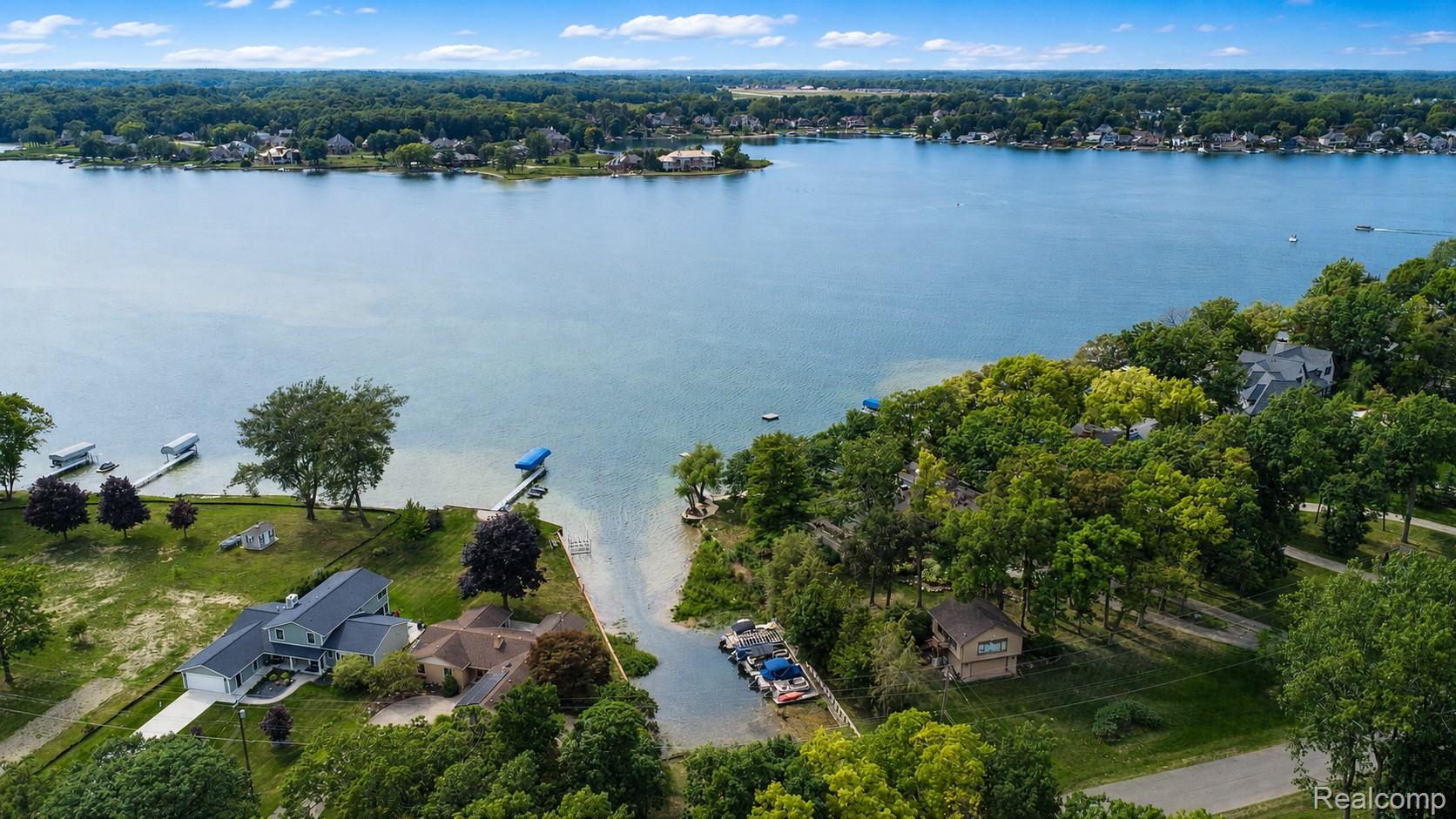 15420 Jennings Road Fenton, MI 48430 - Photo 37 of 45 Waterfront property featuring a private dock, lush surrounding trees, and direct lake access