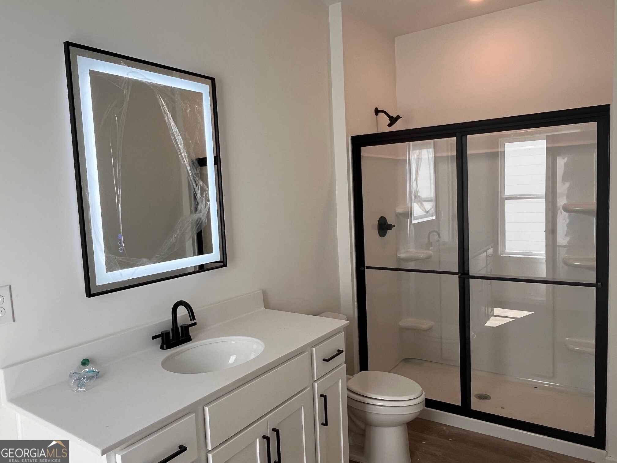 183 Jackson Heights, Unit 4 Cleveland, GA 30528 - Photo 14 of 28 Primary bath has walk in shower and a back lit mirror.