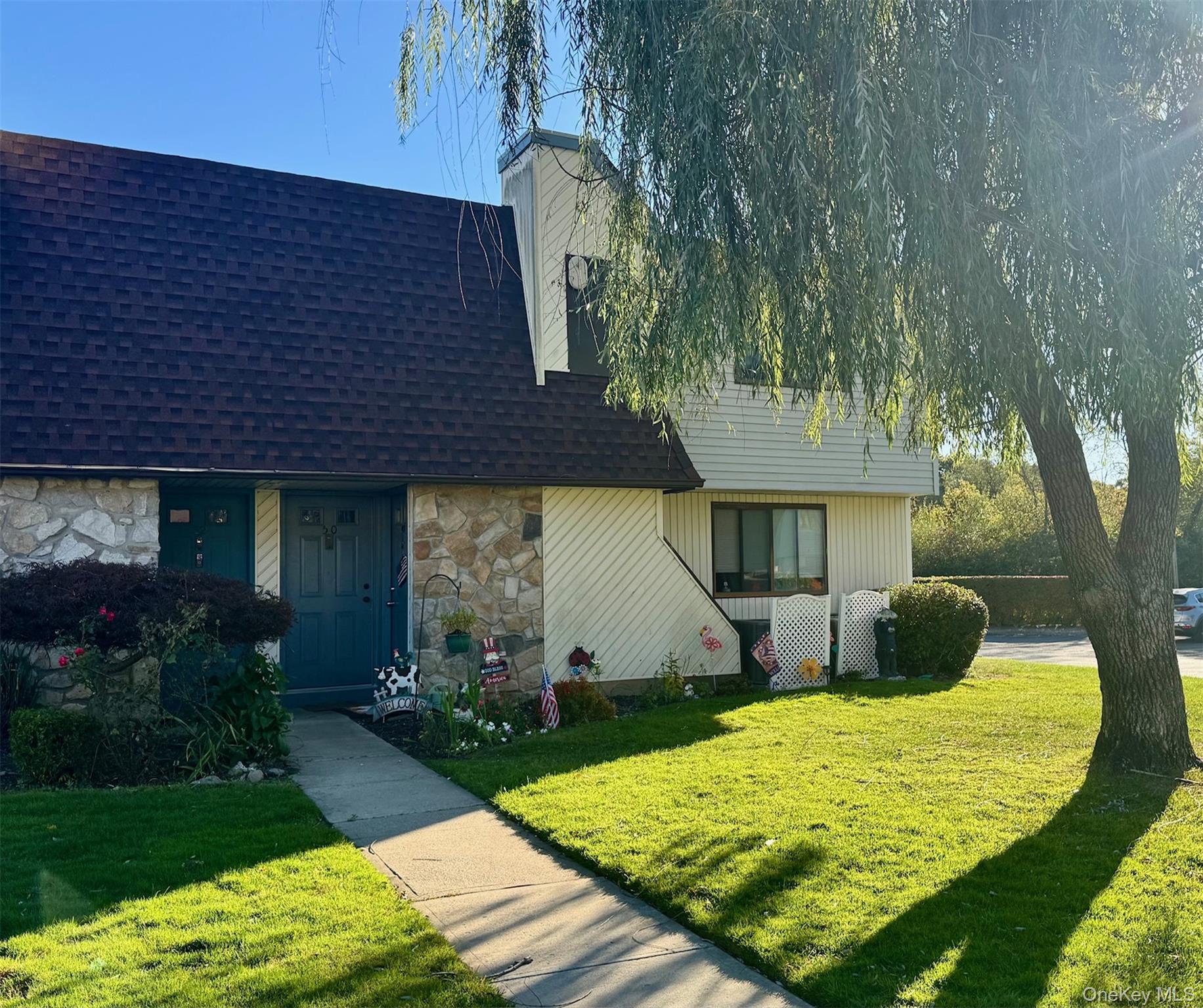 49 Pointe Circle South, Unit 49 Coram, NY 11727 - Photo 1 of 16 a front view of a house with garden