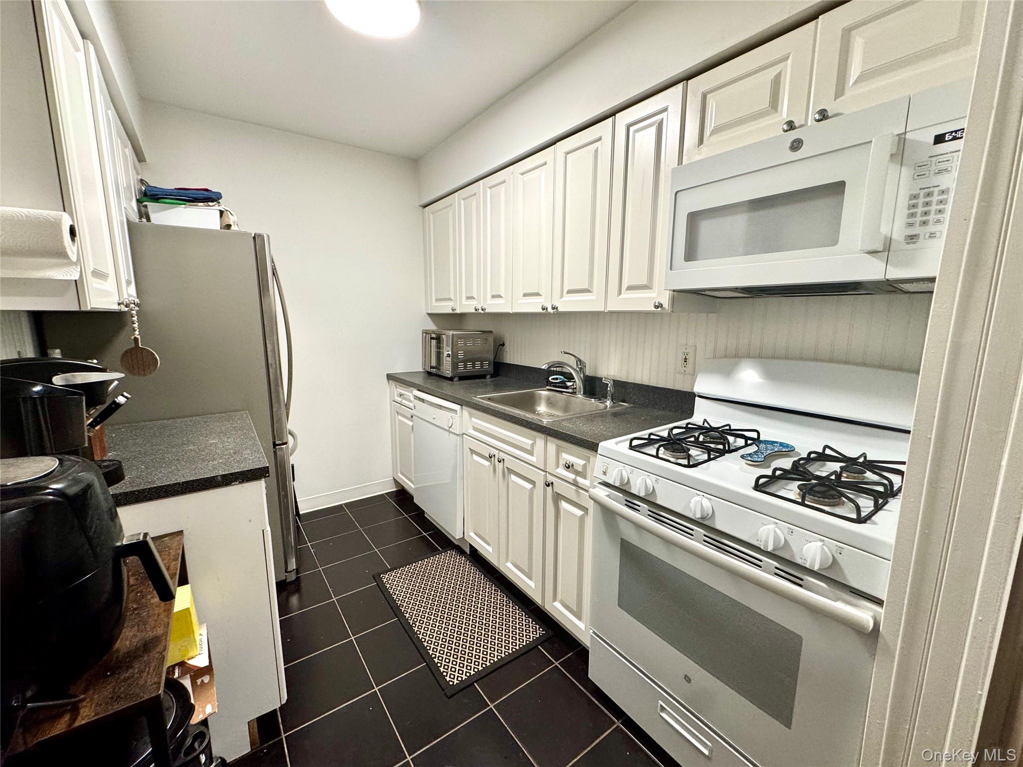 49 Pointe Circle South, Unit 49 Coram, NY 11727 - Photo 2 of 16 a kitchen with stainless steel appliances granite countertop a stove a refrigerator and a microwave