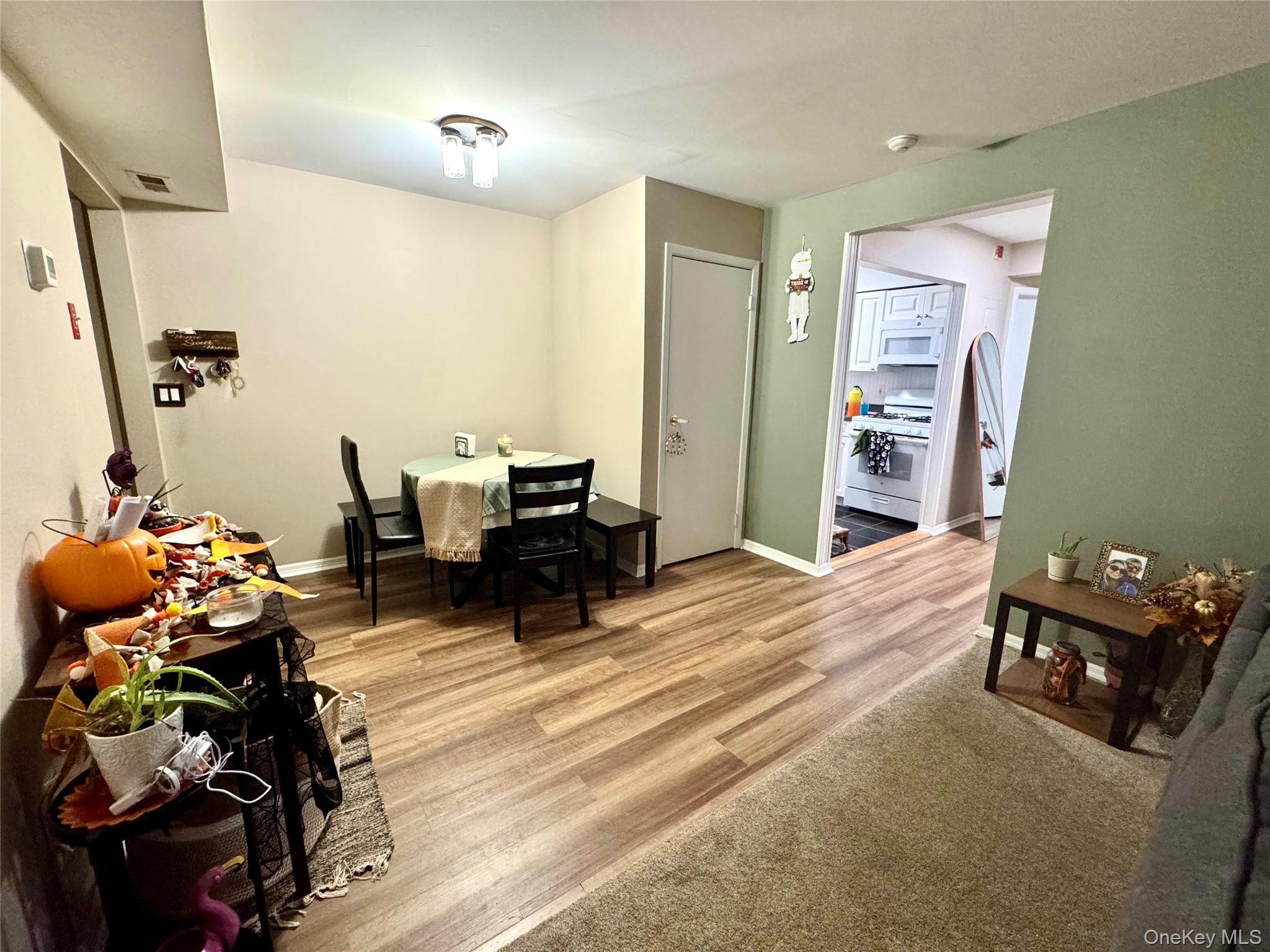49 Pointe Circle South, Unit 49 Coram, NY 11727 - Photo 8 of 16 a living room with furniture and a chandelier