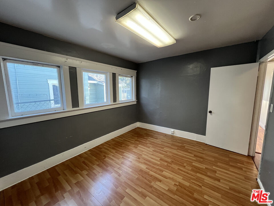 1606 North Bush Street Santa Ana, CA 92706 - Photo 7 of 13 a view of an empty room with wooden floor and a window