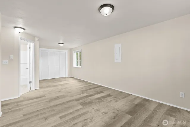 an empty room with wooden floor and windows