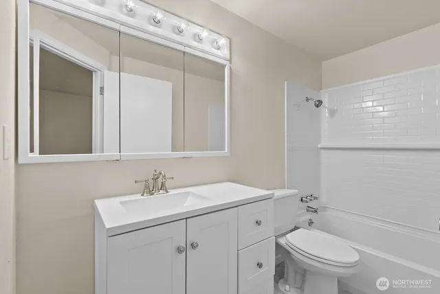 a bathroom with a sink toilet vanity and shower