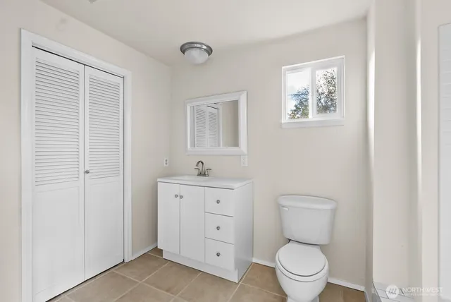 a bathroom with a toilet a sink and mirror
