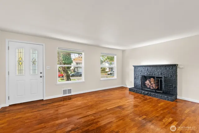 an empty room with window and fireplace