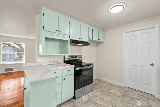 a kitchen with stainless steel appliances granite countertop a stove a sink and a microwave