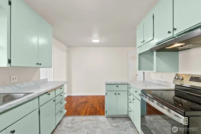 a kitchen with stainless steel appliances granite countertop a sink stove and cabinets