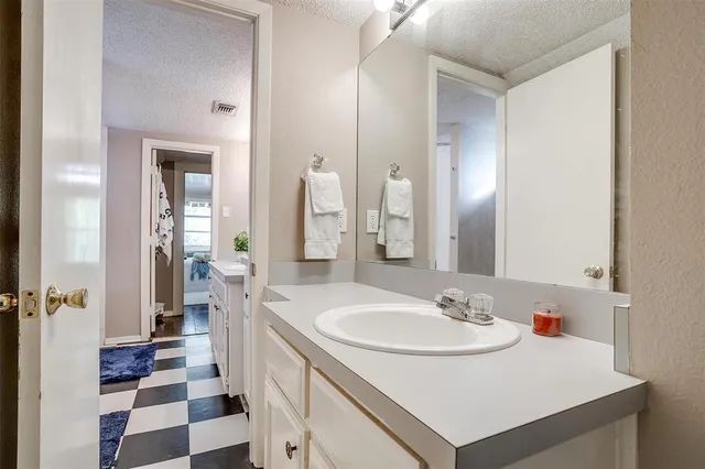 a bathroom with a sink a potted plant and a shower