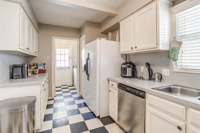 a kitchen with stainless steel appliances a refrigerator sink and cabinets