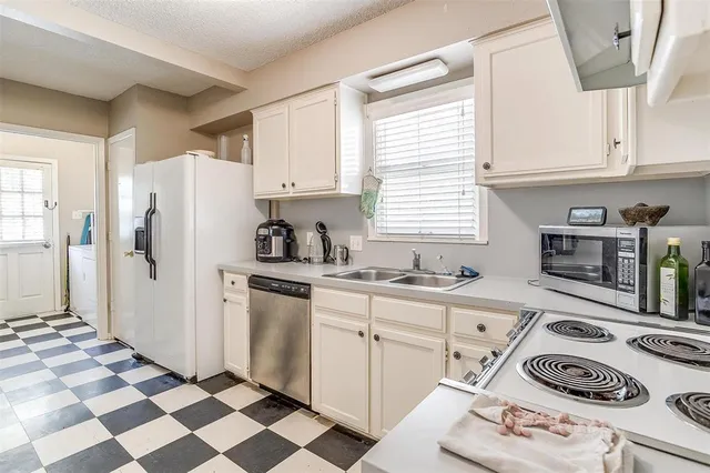 a kitchen with granite countertop white cabinets and white appliances