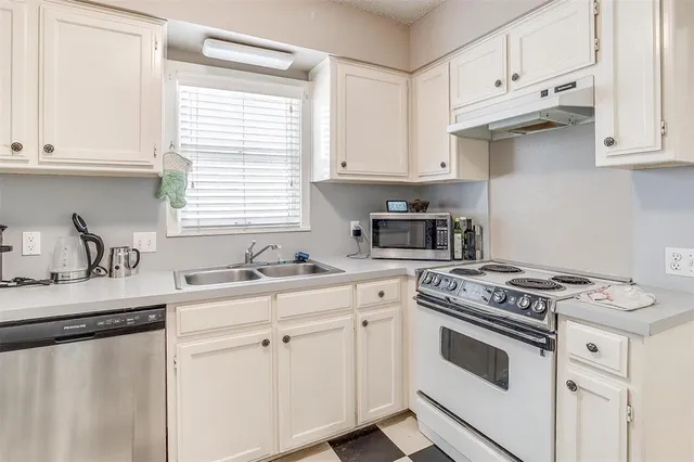 a kitchen with stainless steel appliances a stove a sink and a refrigerator