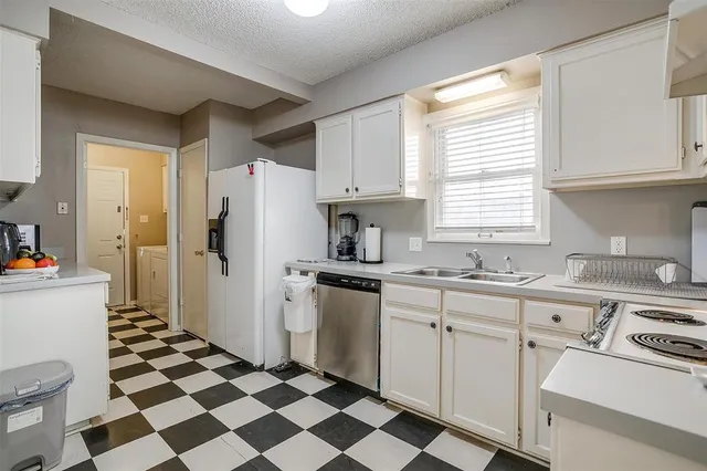 a kitchen with a sink a refrigerator and cabinets