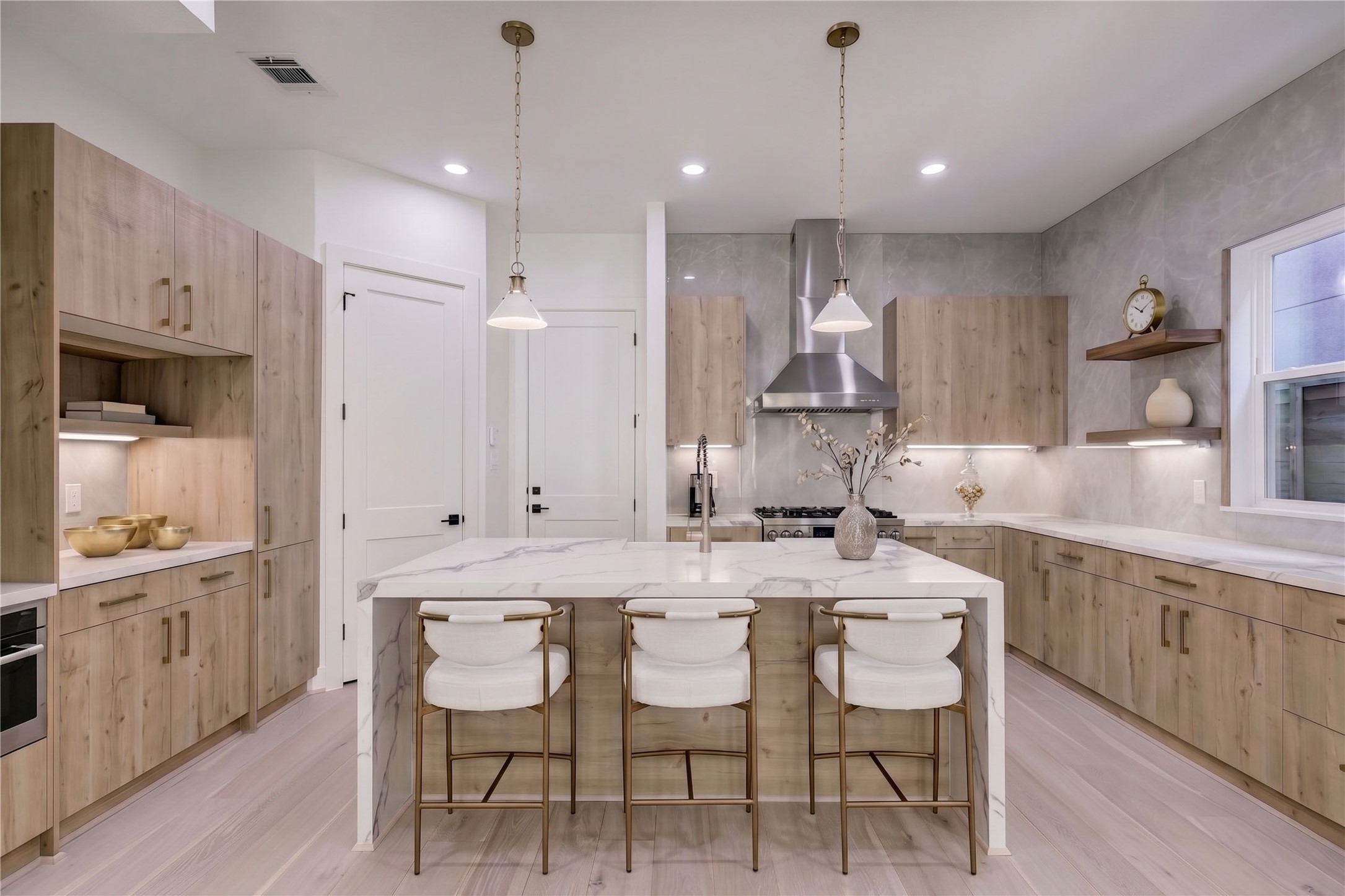 6209 Westcott Street Houston, TX 77007 - Photo 3 of 16 Kitchen – Located on the first floor, this beautifully designed kitchen features a double waterfall-edge island with quartz countertops, abundant cabinets, and a walk-in pantry. (virtual staging)