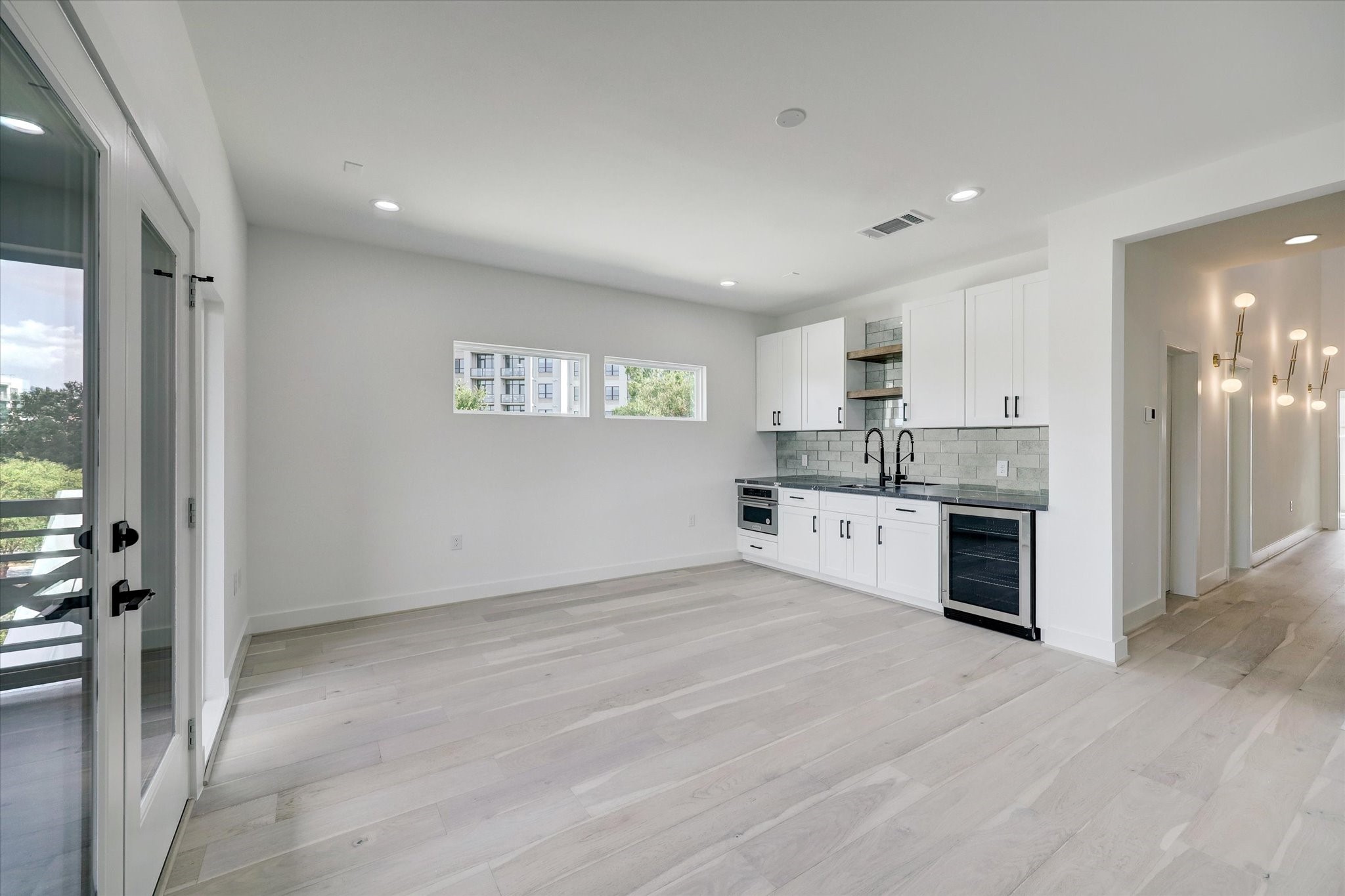 6209 Westcott Street Houston, TX 77007 - Photo 10 of 16 Game Room – Located on the third floor, this expansive entertainment space features a stylish bar area with custom built-ins, a beverage/wine cooler, sink, and microwave.