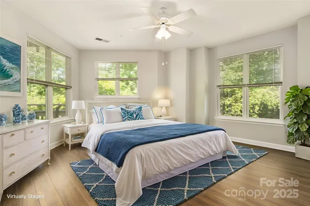a bedroom with a large bed and windows