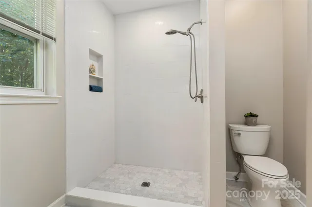 a bathroom with a toilet and a shower