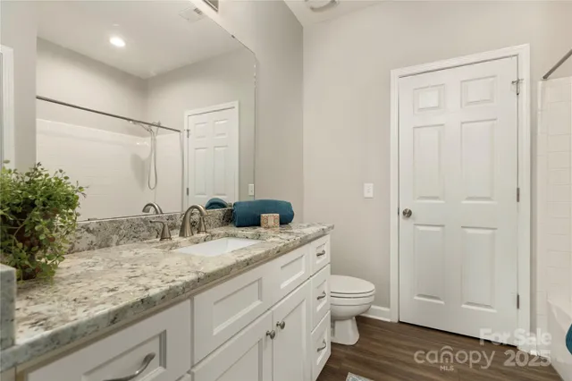 a bathroom with a granite countertop sink toilet and shower