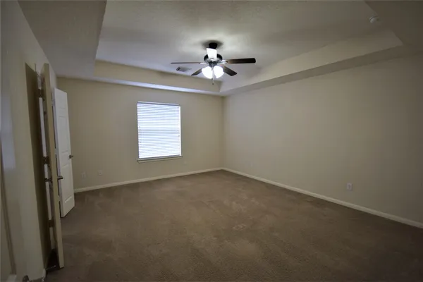 an empty room with a window and a fan