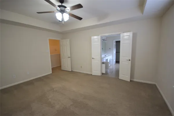 an empty room with closet and a chandelier fan