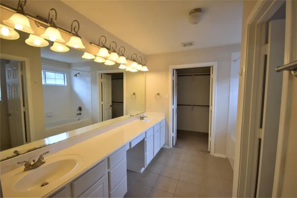 a bathroom with a double vanity sink and a mirror