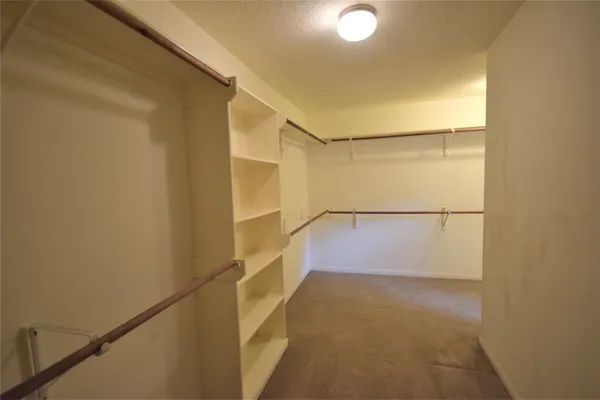 a view of walk in closet with empty racks